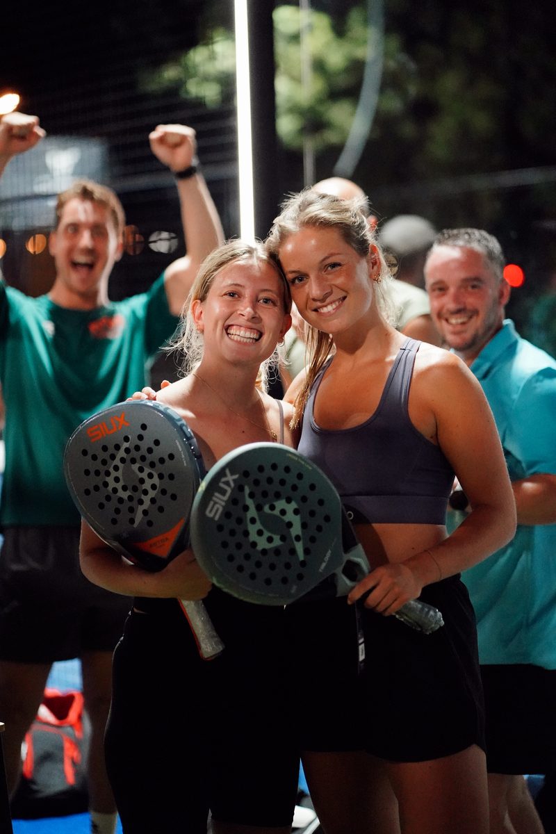 Two winners celebrating with raised paddles after the final