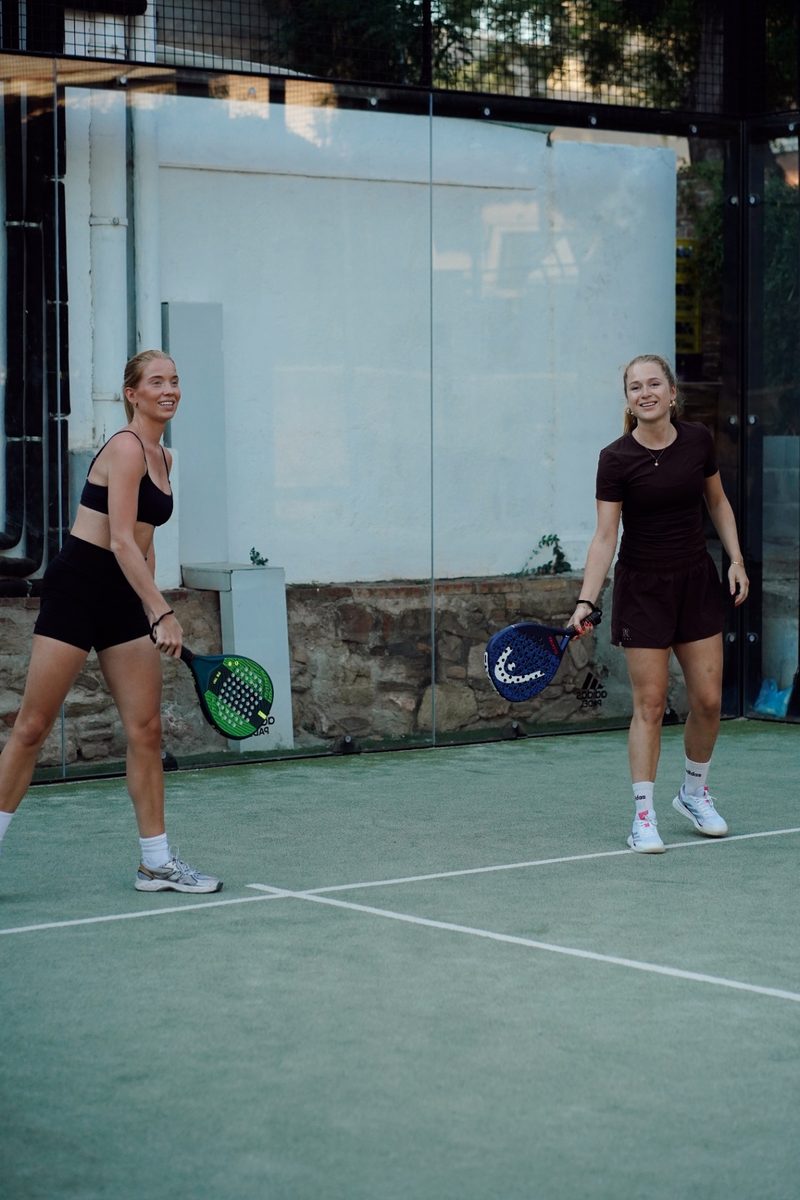 Two women ready at the net with their paddles up