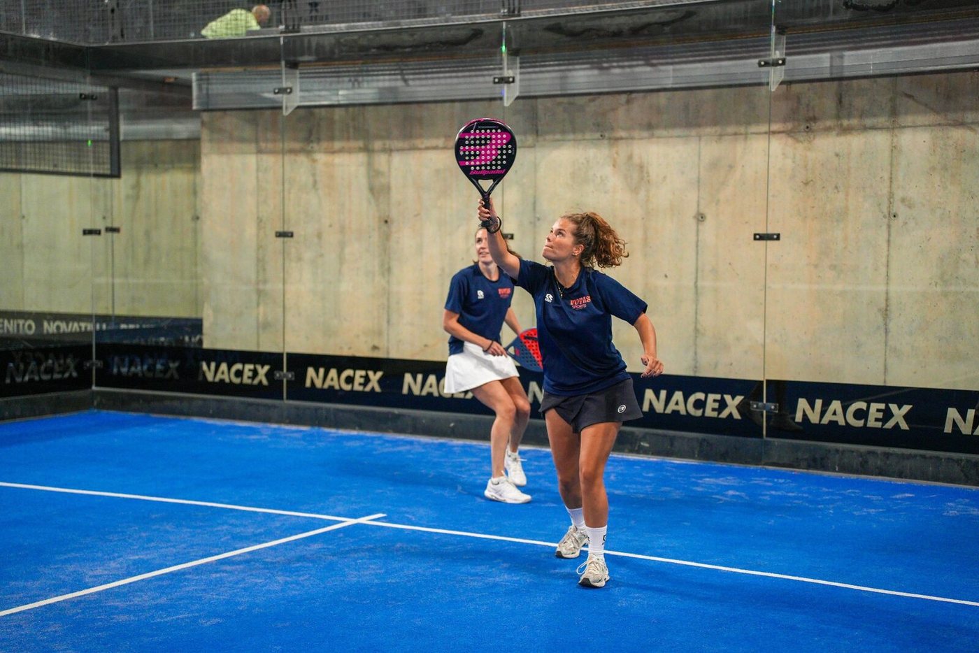 Two women padel players celebrating with the winners trophy